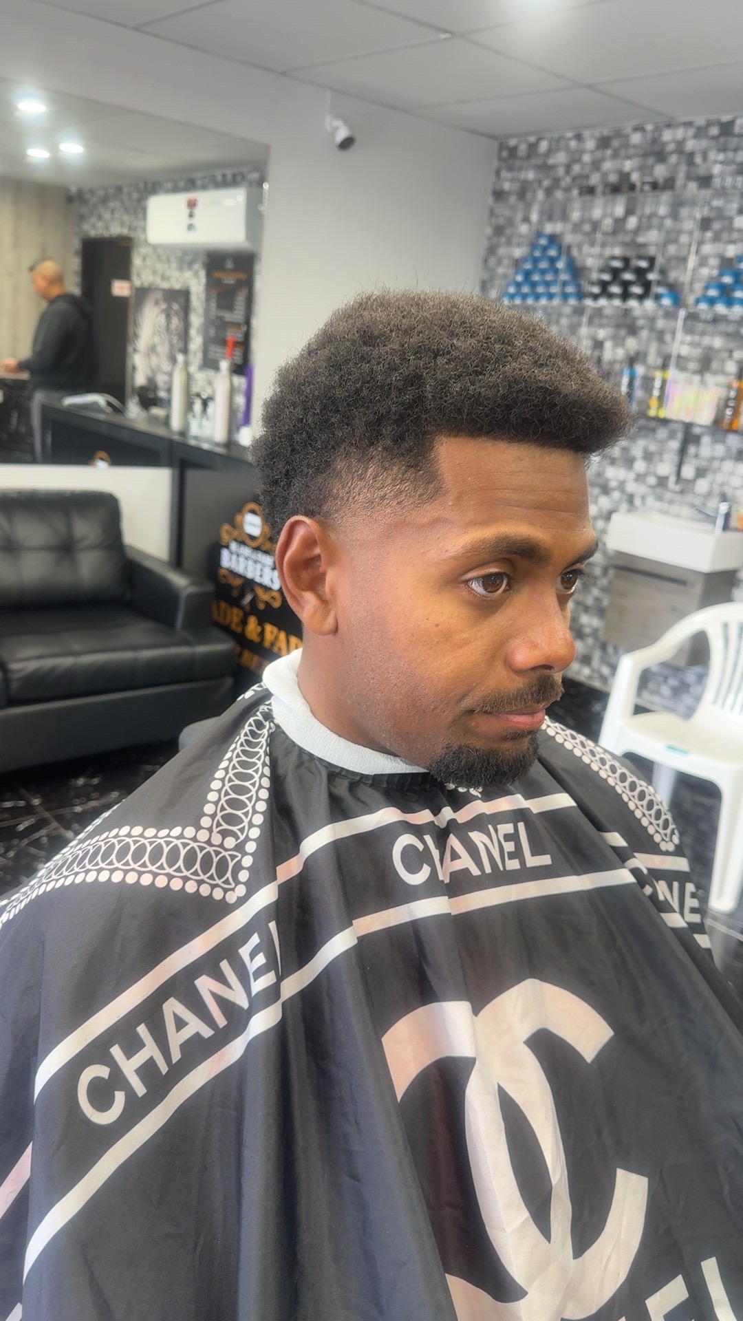 Natural textured hair shaped above a tapered side